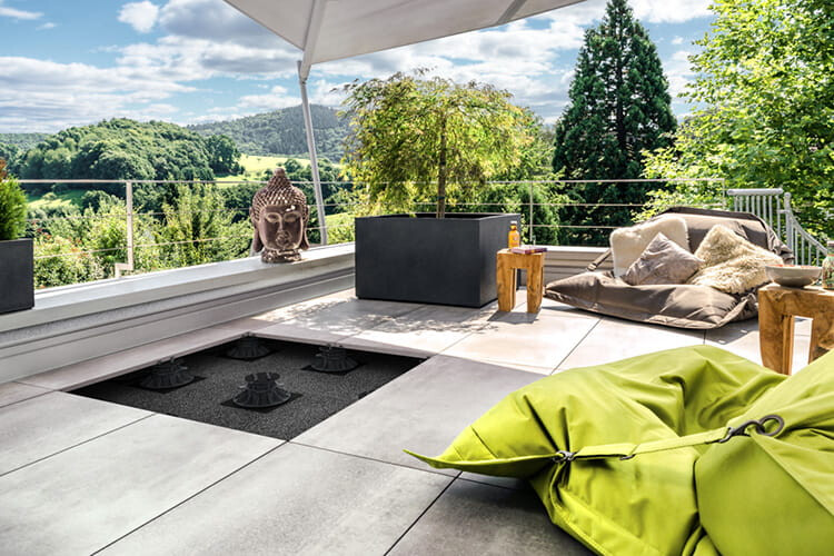 Außenbereich mit Terrassenplatten, Deko-Elementen & einem weiten Blick ins Grüne
