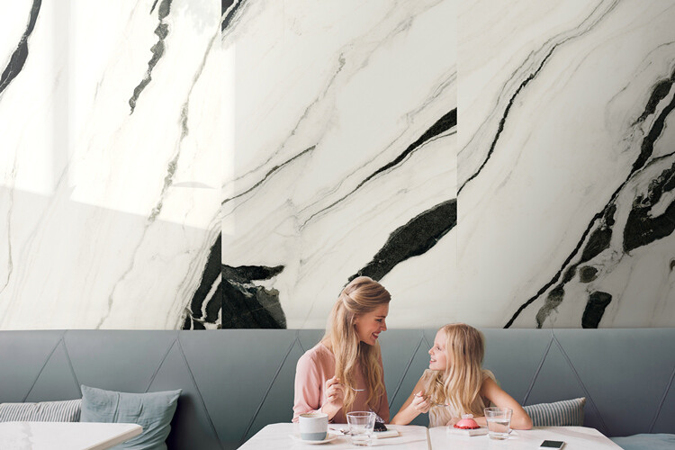 Café mit schwarz-weißen Fliesen im Marmorlook als Wandverkleidung