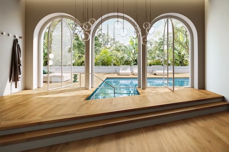 Indoor- & Outdoor-Pool in einem gefliesten Raum mit Holzoptikfliesen