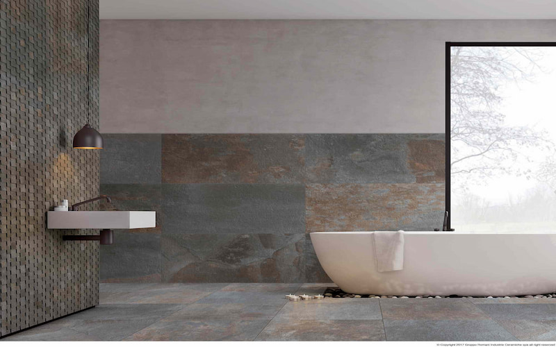 Modernes Badezimmer mit freistehender, ovaler Badewanne und barrierefreien Fliesen in metallisch glänzenden Steinfarben.