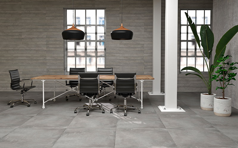 Büro mit großem Schreibtisch, fünf Stühlen, zwei Pflanzen und quadratischen Fliesen in grau