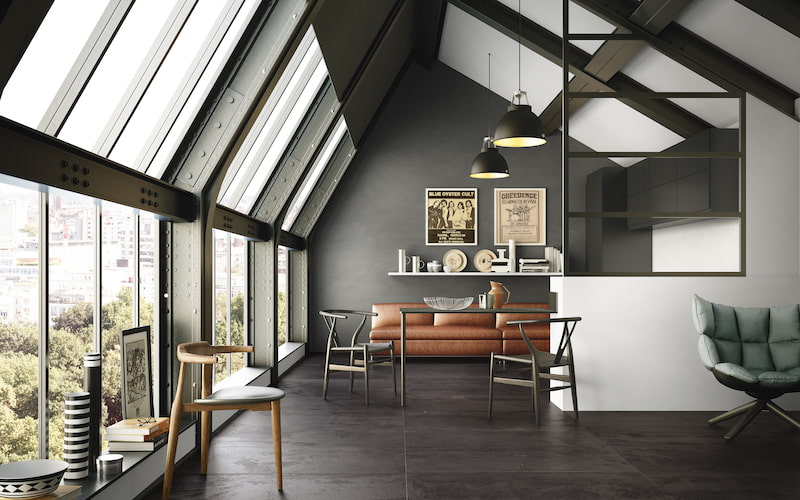 Loftwohnung mit großer Fensterfront, modernen Möbeln und Boden mit Fliesen in Metalloptik